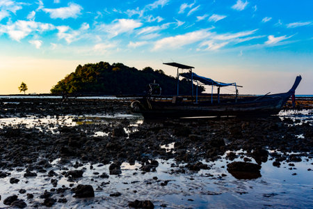 Fishing boat on the beach at low tide in the morning.の写真素材