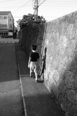 A walking child and a shadow on the wallの写真素材