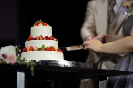 Bride and groom cutting wedding cake togetherの写真素材