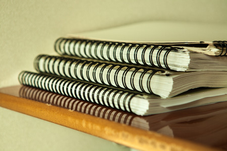 Background with multiple sketchbooks on a wooden deskの写真素材