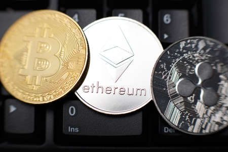 Bitcoin, ethereum and ripple coins on keyboard