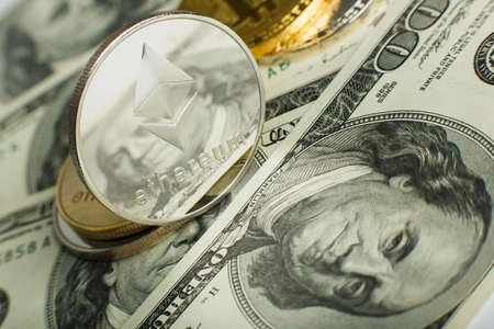 Ethereum coin with other cryptocurrency on dollar notesの写真素材