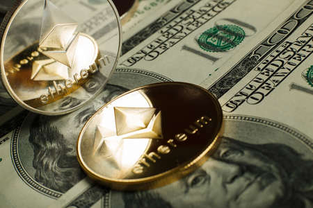 Ethereum coin with other cryptocurrency on dollar notesの写真素材