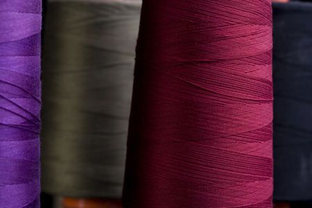 Spools of colored cotton thread, ordered composition, warm colors