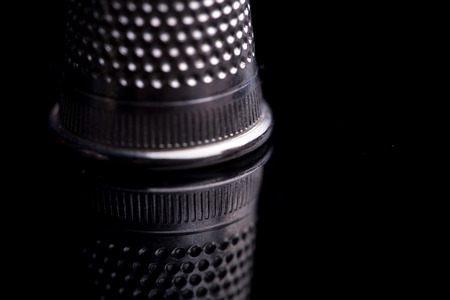 Detail of thimble cutico on a black background mirrorの写真素材