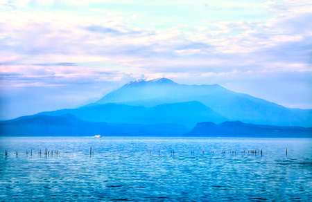 Dreamful view to a cloud-covered mountain by Sirmione at the Lake Garda