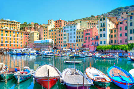 boats in the harbour of the seaport Camogli at the Italian Riviera with a gorgeous colored house facade and luminous shining blue skyのeditorial素材