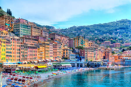 bathing beach in the seaport Camogli at the Italian Riviera with a gorgeous colored house facade and luminous shining blue skyのeditorial素材