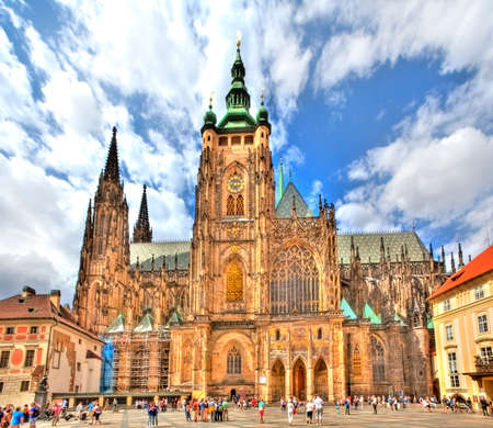 The famous St. Vitus Cathedral in the Prague Castle in Prague in the Czech Republic on a beautiful sunny day with light clouds at a brightly blue skyの写真素材