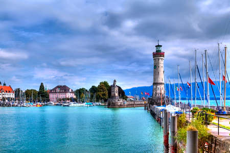 View to the harbor on the Iceland of Lindau at Lake Constance in the south of Germany with the the historical lighthouseの写真素材