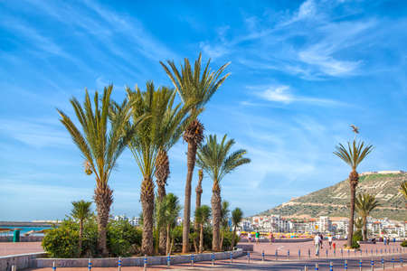 On the beach promenade of the African harbor city Agadir in Morocco with a view to the kasbahの写真素材