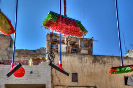 Colorful brooms hanging in front of a shop in the medina of Fes in Morocco in Africa before a...