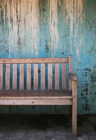 Bench with graffiti against a blue wallの写真素材