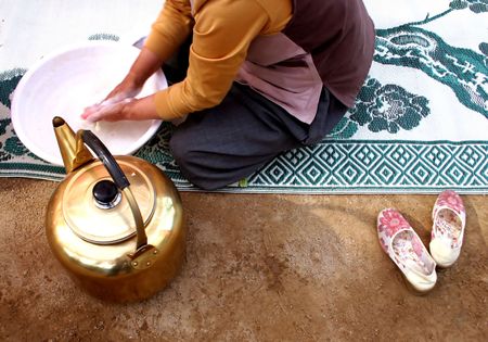 Woman washing her hands in a tub of waterの写真素材