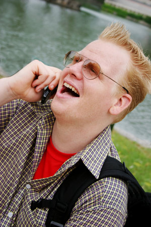 Man laughing while talking on the telephoneの写真素材