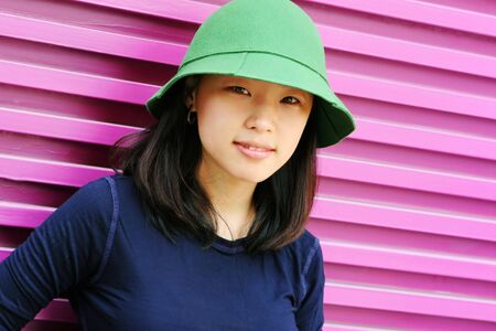 Pretty Korean woman wearing a green hat and navy blue topの写真素材