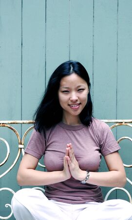 Beautiful young Korean woman sitting on a benchの写真素材