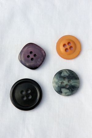 Four buttons on white cotton