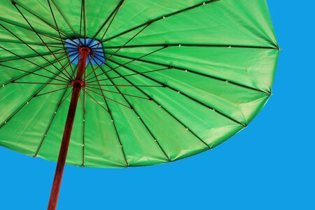 Bright green umbrella against a blue sky - travel and tourismの写真素材