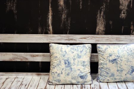 Blue and white floral pillows on a white painted benchの写真素材