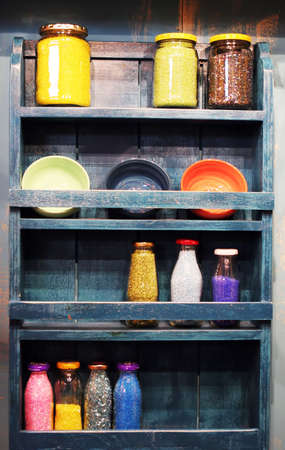 Shelf full of bottles of beads and craft supplies - home interiorsの写真素材