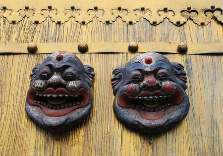 Asian masks on a gold door - travel and tourism.の写真素材