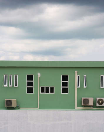 Exterior of an industrial building with dark clouds in the sky.の写真素材