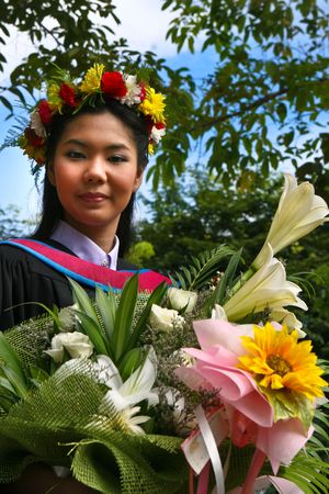 Beautiful young Asian graduate in robes on graduation day.の写真素材