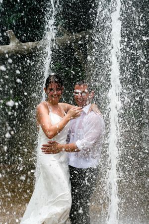Bride and groom dancing under a water fountain on their wedding day.の写真素材