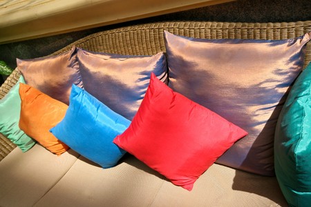 Close-up of a sofa covered in colorful silk cushions.の写真素材
