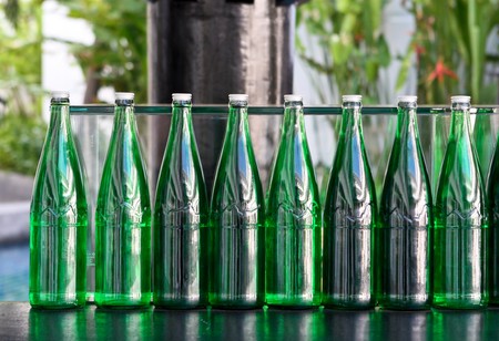 Row of bright green bottles on a bar.の写真素材
