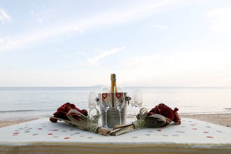 Chilled champagne and wine glasses on a table at the beach.の写真素材
