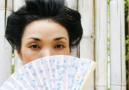 Beautiful Japanese woman in kimono with a fan.