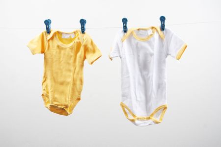 Baby outfits hanging on a clothes line - isolated.の写真素材