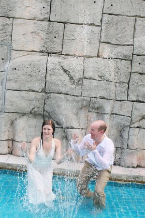 Gorgeous bride and groom playing in the water during a trash the dress photo shoot.の写真素材