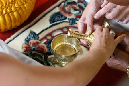 Close-up of hands during a traditional Buddhist wedding in Thailand.の写真素材
