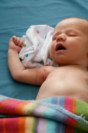Cute newborn baby under a blanket.