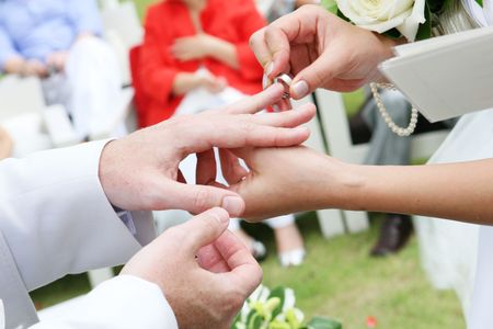 Close-up of a couple exchanging wedding rings during a ceremony.の写真素材