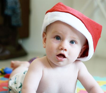 Cute infant wearing a red Christmas hat.の写真素材