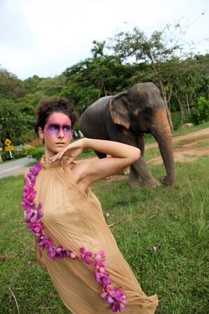 Fashion portrait of a model with an elephant.の写真素材