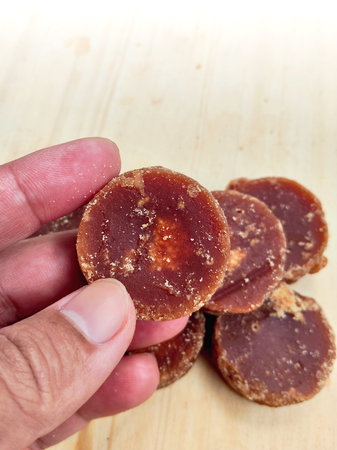 Slices of brown sugar on a wooden background. Selective focus. Shallow depth of field.の写真素材