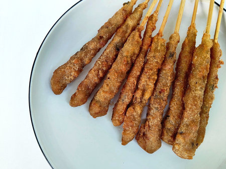 Fried skewers in white dish on white background.の写真素材