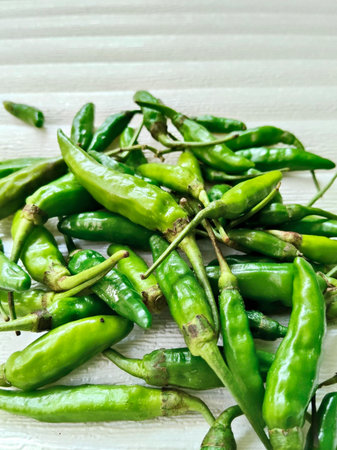 Green hot chili peppers on a wooden background. Selective focus.