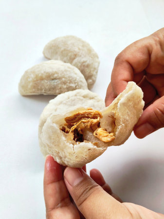 Cireng, a chewy and crispy traditional Indonesian snack, with one piece showing its savory filling,...