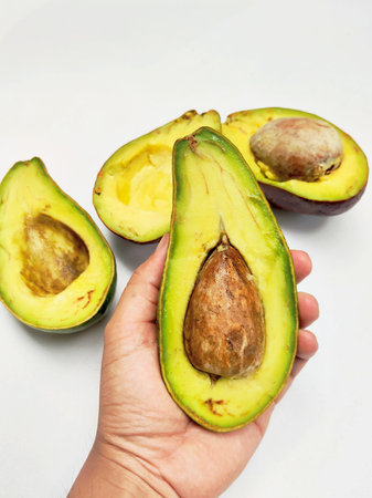 Avocado fruit in hand on white background. Healthy food concept.
