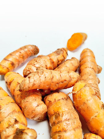 Fresh turmeric root on white background, closeup of photo.