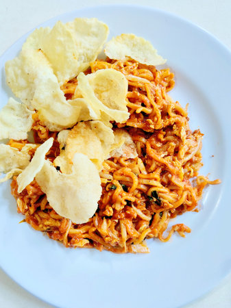 Fried noodle with fish and potato chips on white plate.の写真素材
