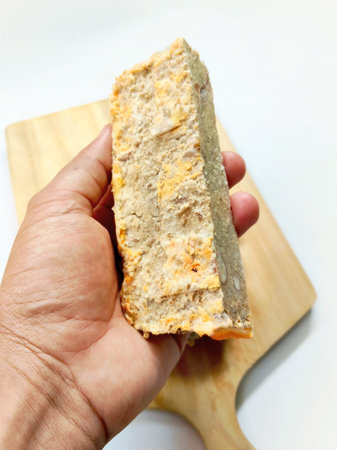 Southeast Asian Culinary Tradition: Sweet and Savory Oncom Slices on Rustic Wooden Chopping Block.