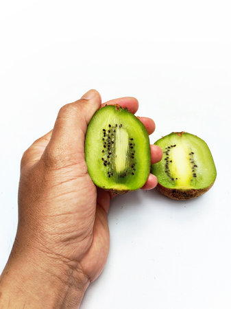 Fresh kiwi fruit in hand isolated on the white background.の写真素材