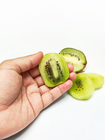Kiwi fruit in hand isolated on white background with clipping pathの写真素材